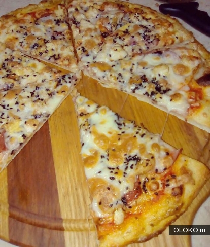 Пицца с чёрным кунжутом, сыром, беконом, курицей и ветчиной. 